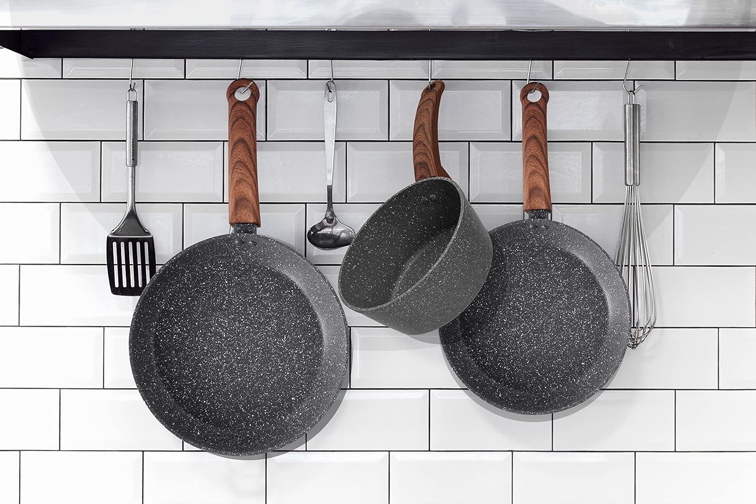Kitchen Utensils Including Two Granite Fry Pans Hanging on a Rack