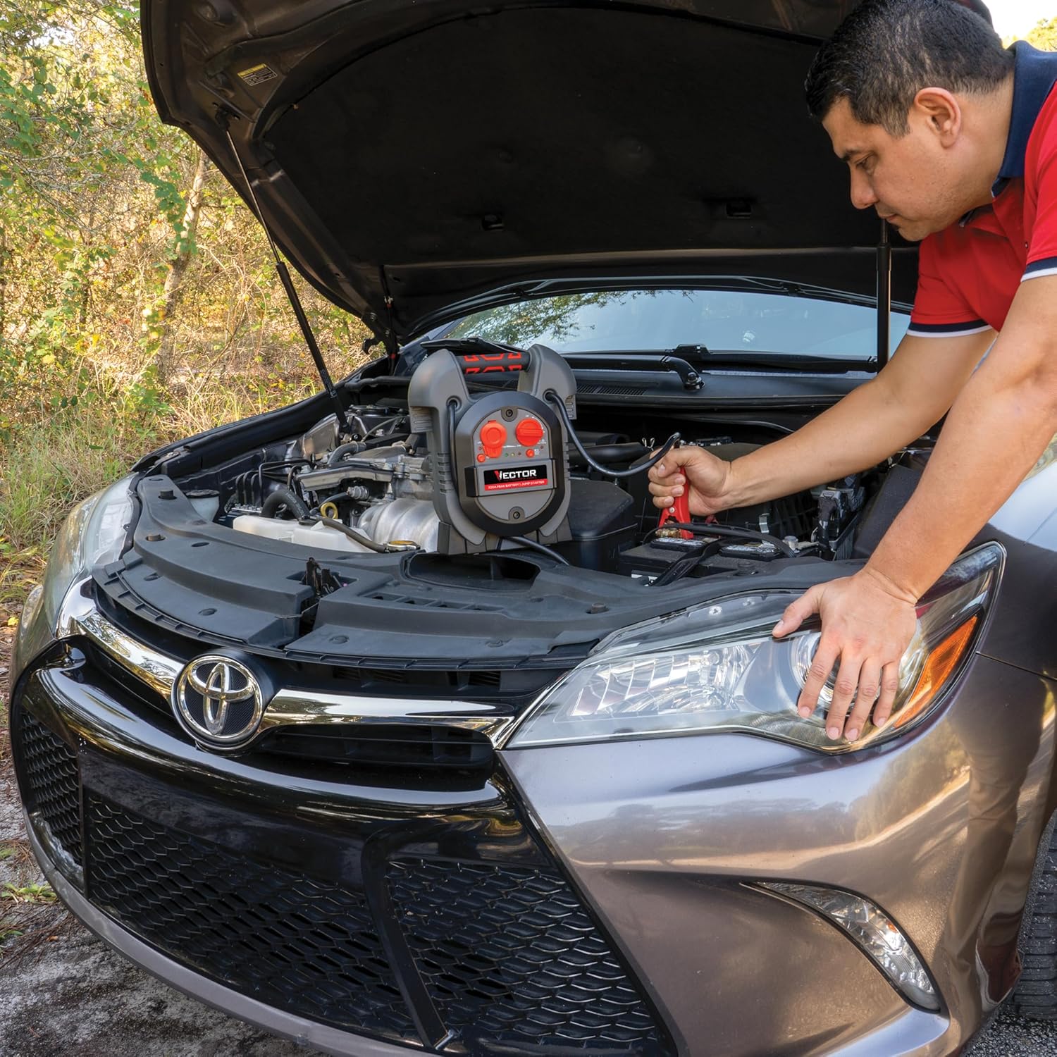 บุคคลกำลังสตาร์ทรถยนต์โดยใช้เครื่องสตาร์ทรถยนต์ VECTOR J312V