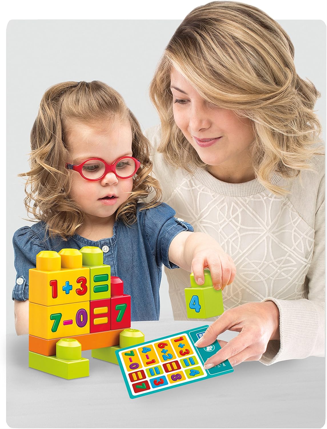 Child and adult arranging Mega Bloks with numbers and math symbols to form equations.