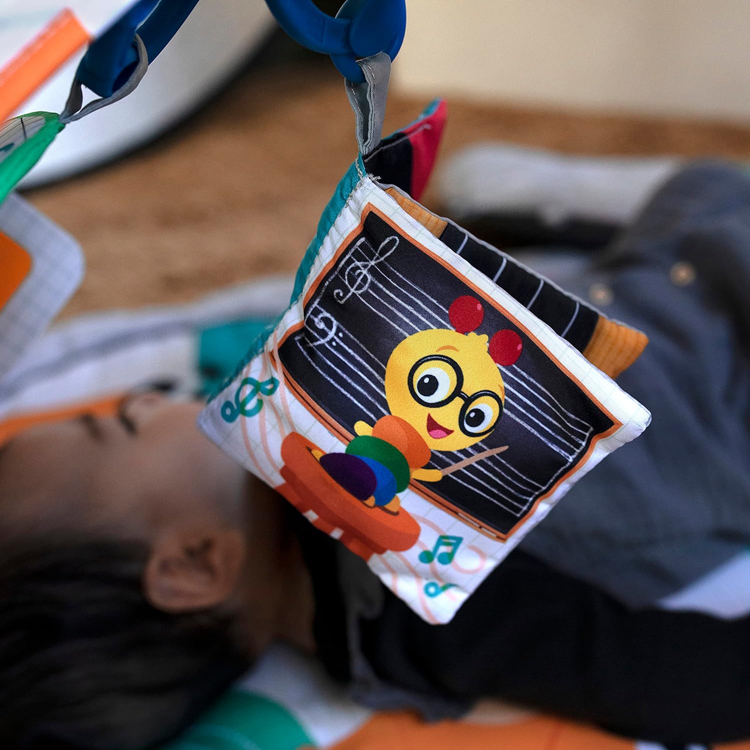 Close-up of a hanging music note toy, part of the activity gym.