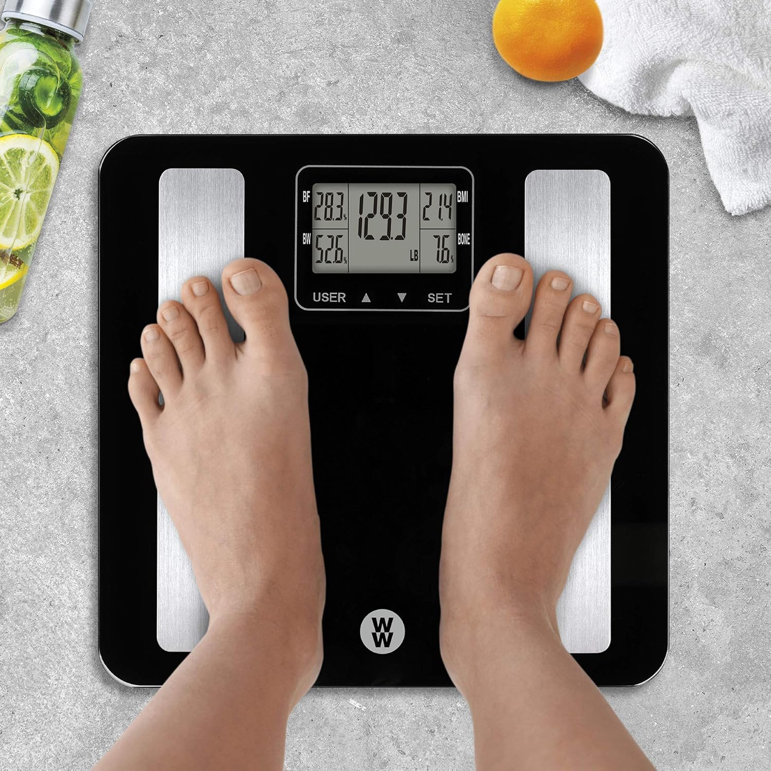 Person standing on Conair WW702XF scale showing body analysis readings