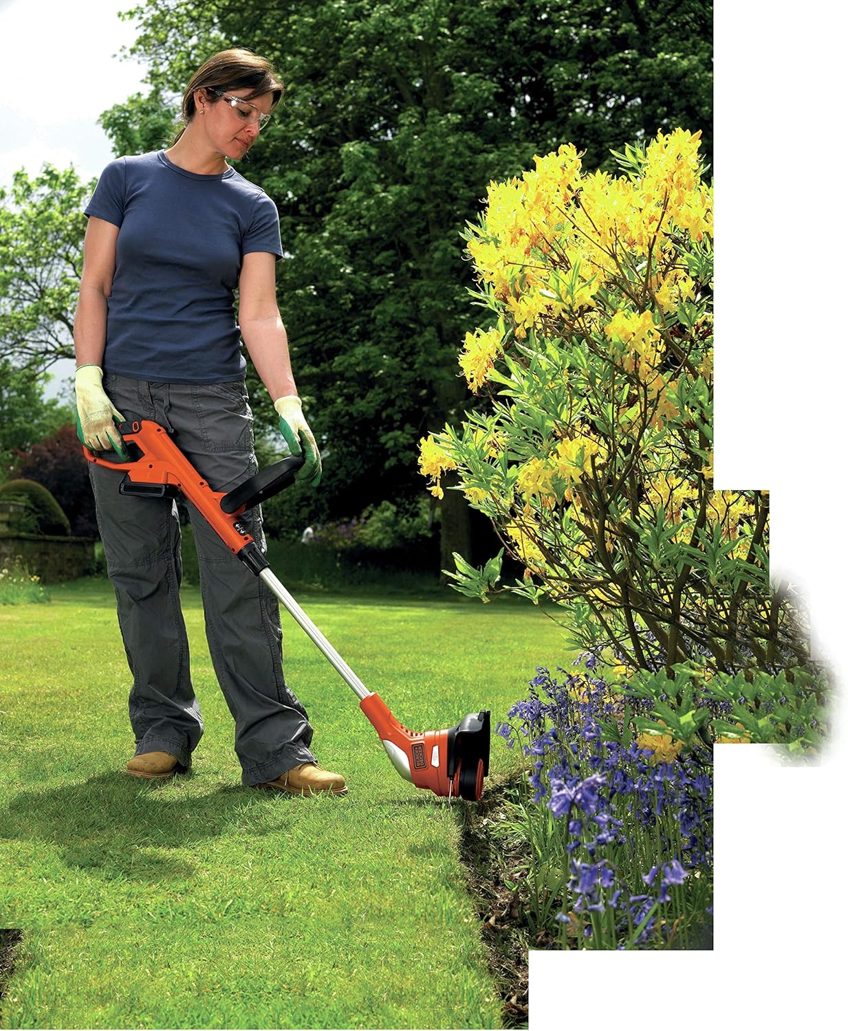 Donna che utilizza il decespugliatore BLACK+DECKER in modalità bordatura lungo un sentiero del giardino