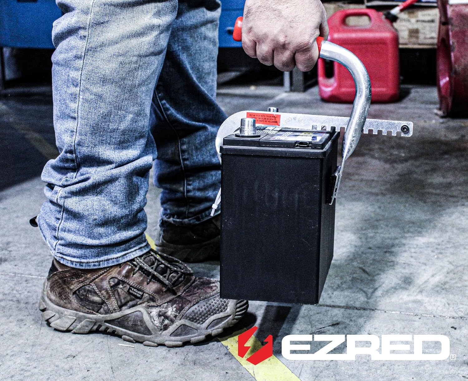 Person using EZ RED BK520 Side Battery Lifter to carry a car battery