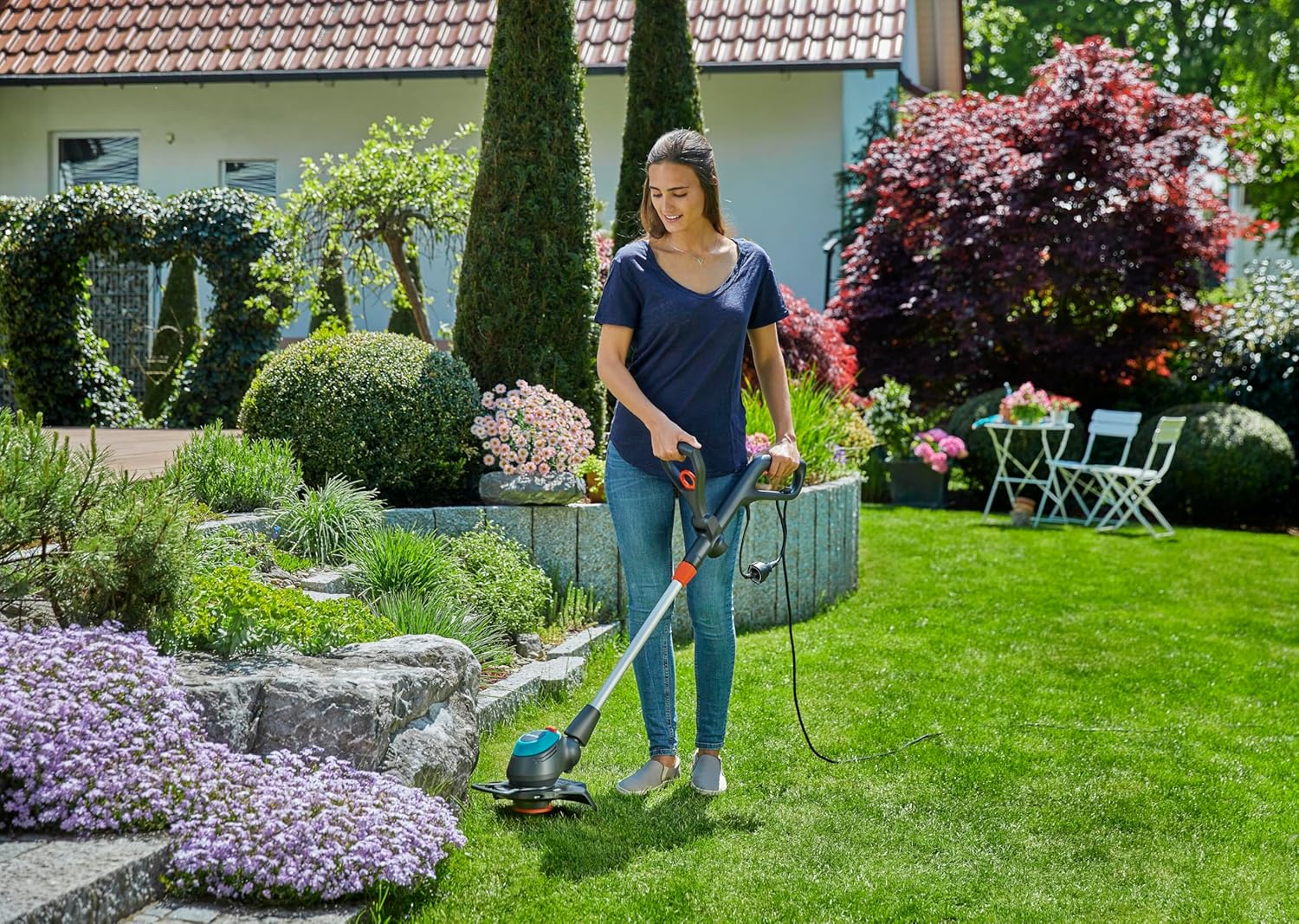 Woman using GARDENA EasyCut 09870-20 Electric Trimmer in a garden
