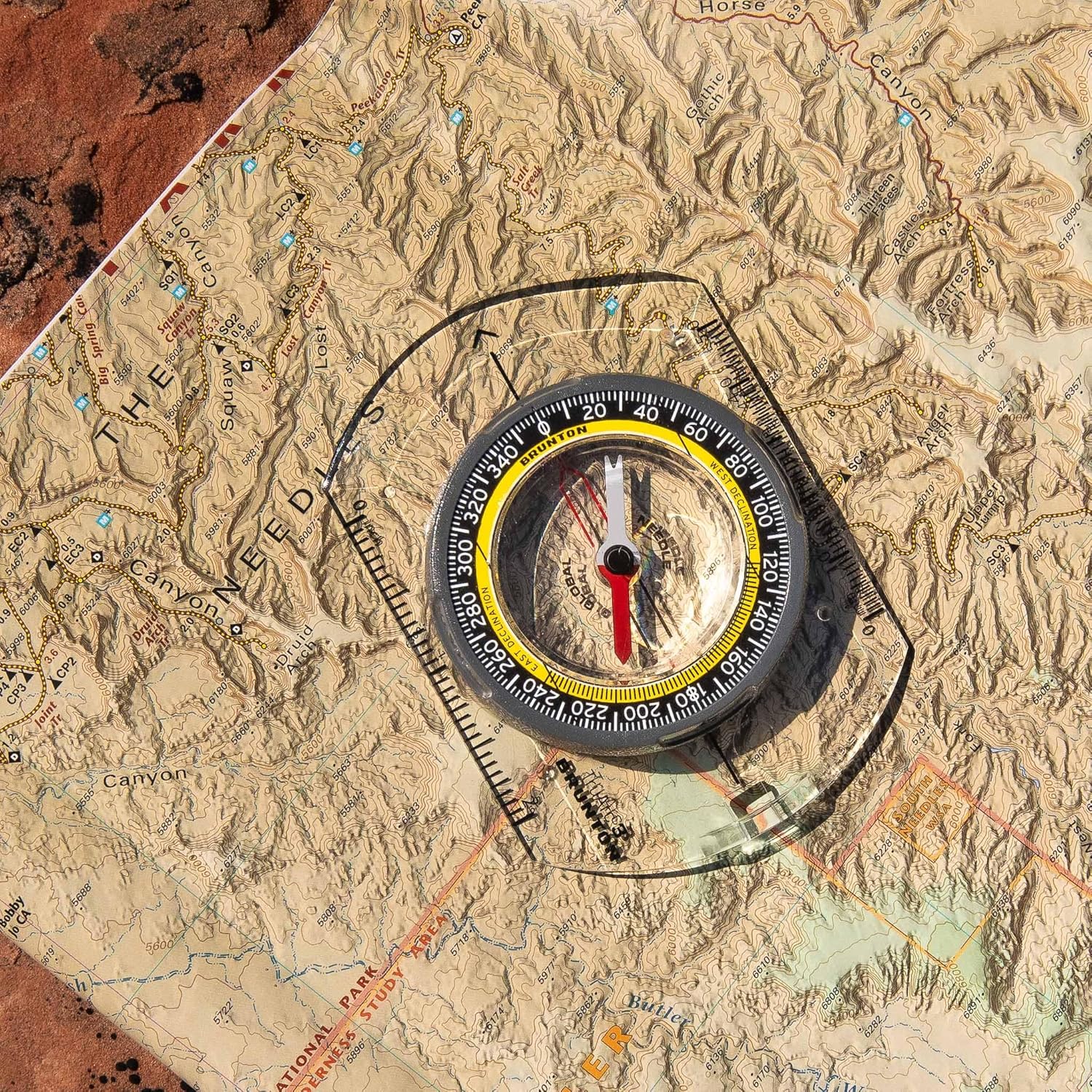 Brunton TruArc 3 compass placed on a topographic map, ready for orientation.