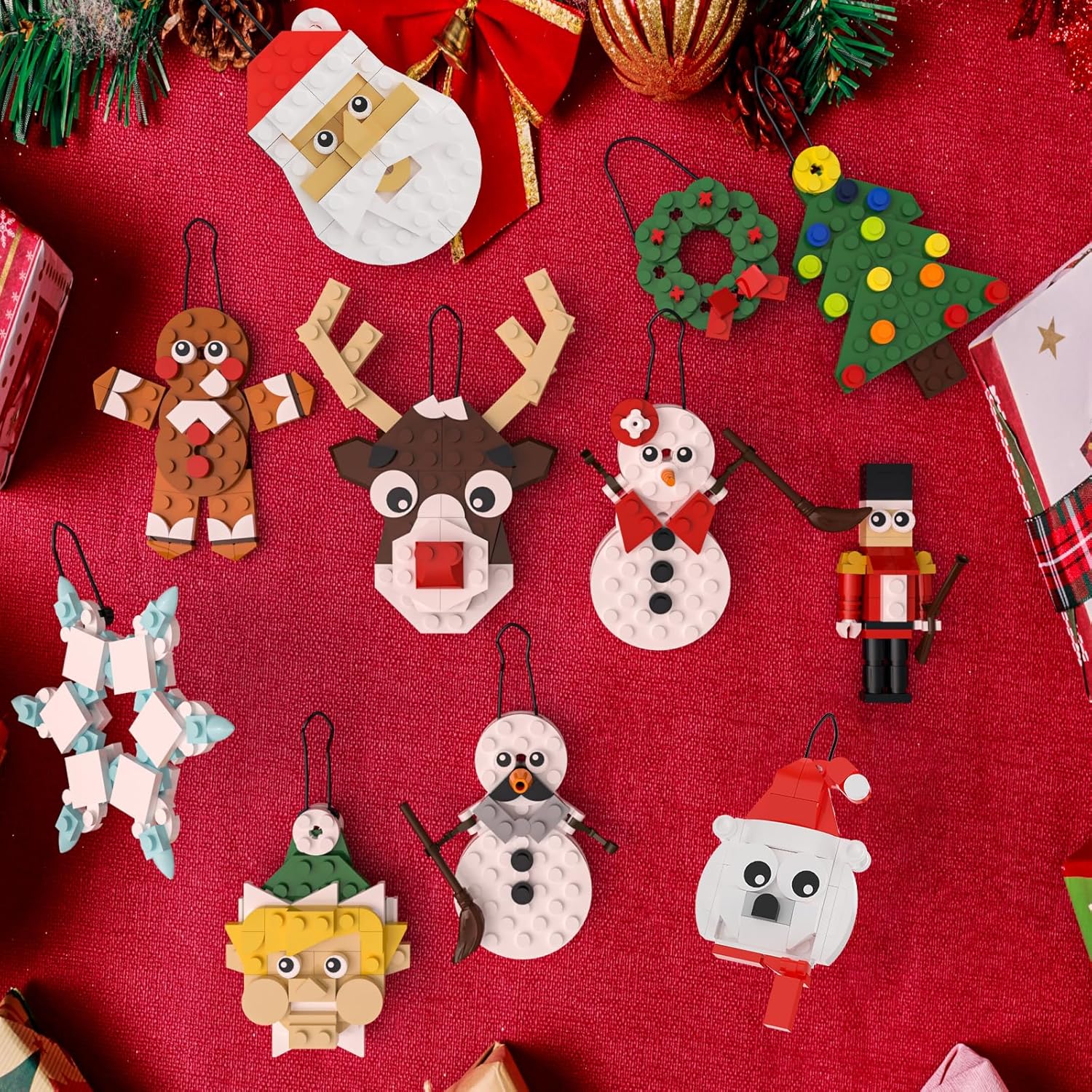 A display of all 11 completed Christmas ornaments, including Santa, Snowflake, Wreath, Christmas Tree, Reindeer, Snowmen, Gingerbread man, Elf, Polar Bear, and Nutcracker, arranged on a red background.