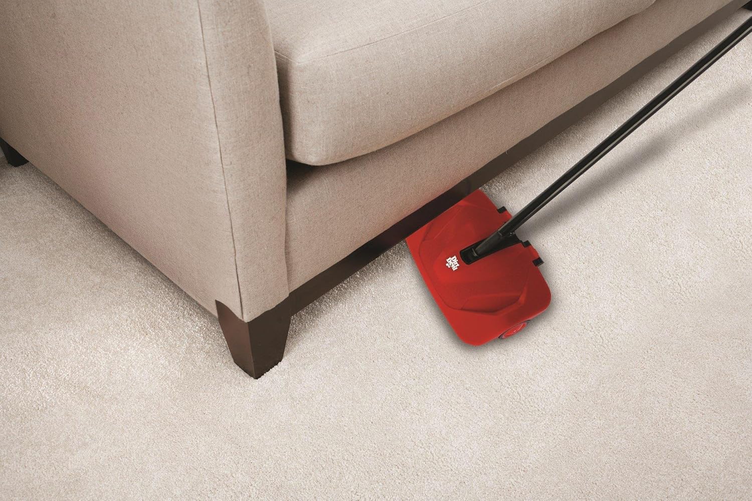 Dirt Devil Simpli-Sweep Manual Push Sweeper reaching under furniture.
