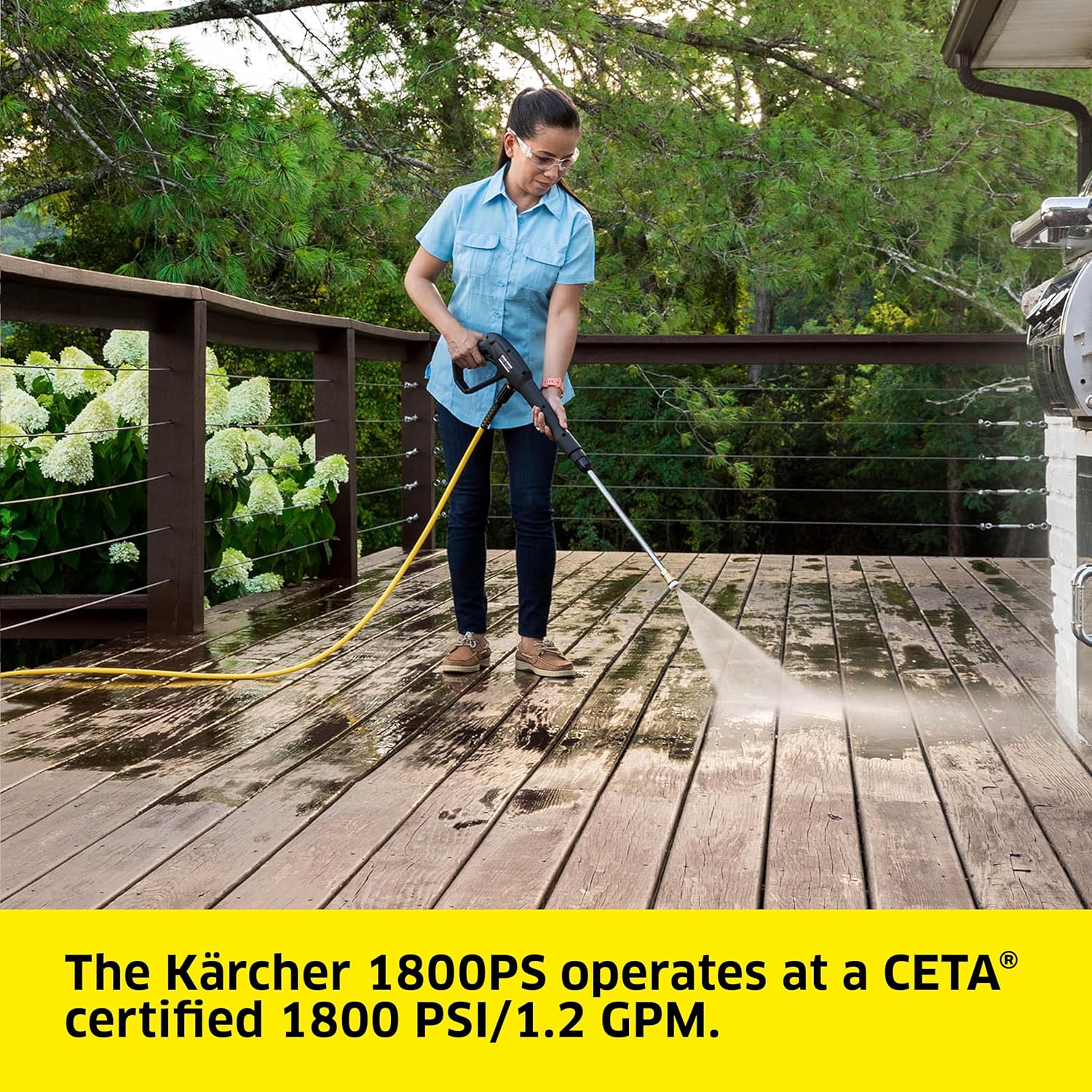 Woman cleaning a wooden deck with the pressure washer