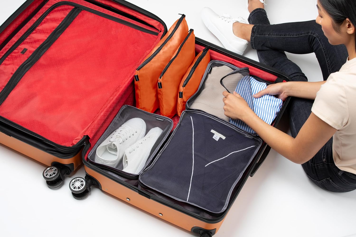 Image of a person organizing a suitcase with Brookstone packing cubes.