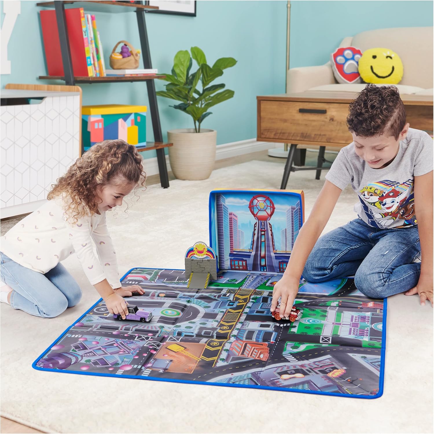 Two children playing with the Paw Patrol True Metal Adventure City Play Mat Set, pushing vehicles across the mat.