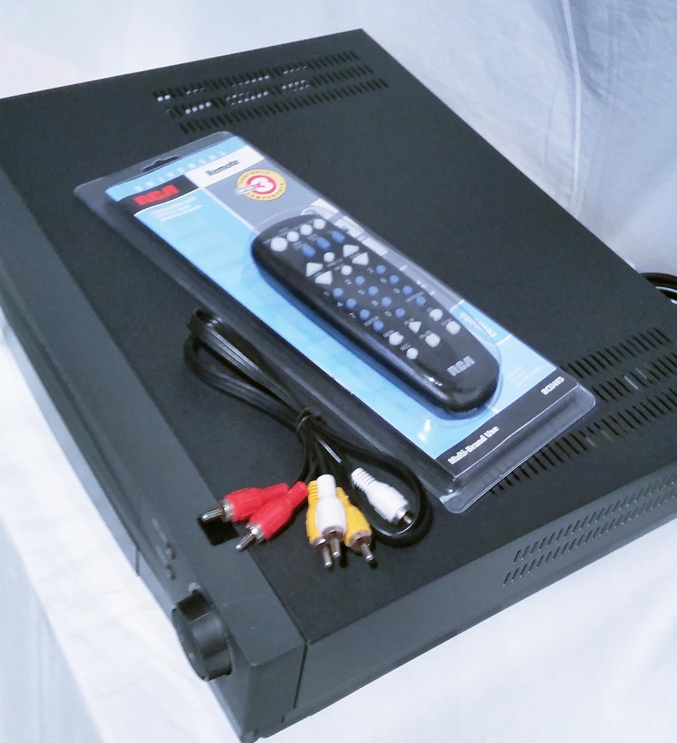 ടോപ്പ് ഡൗൺ view of the Proscan PSVR62 VHS VCR player with remote and RCA cables.