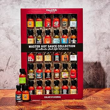 Four colorful miniature bottles of hot sauce arranged neatly