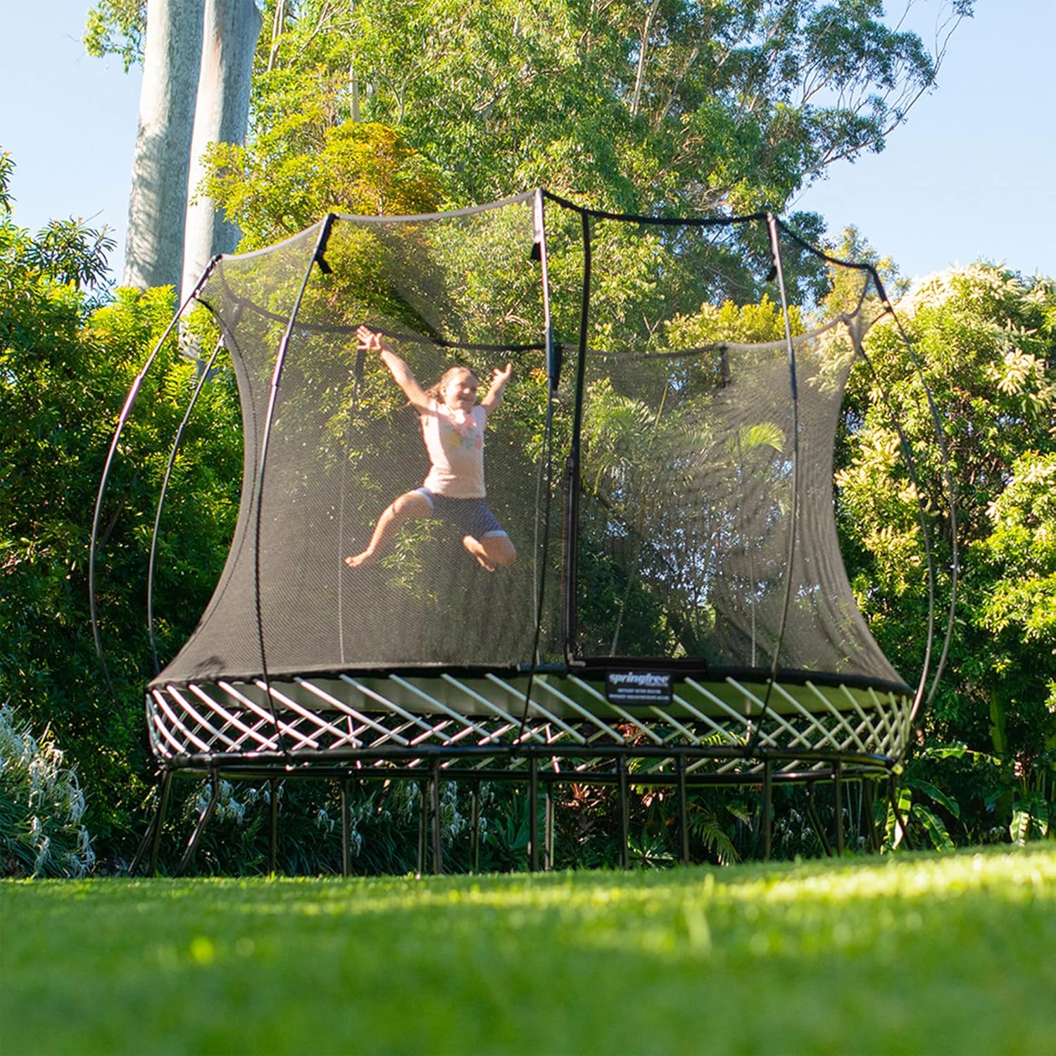 Unplugged kids activities young girl jumping on Outdoor Trampoline with Basketball Hoop - 90s trend activities