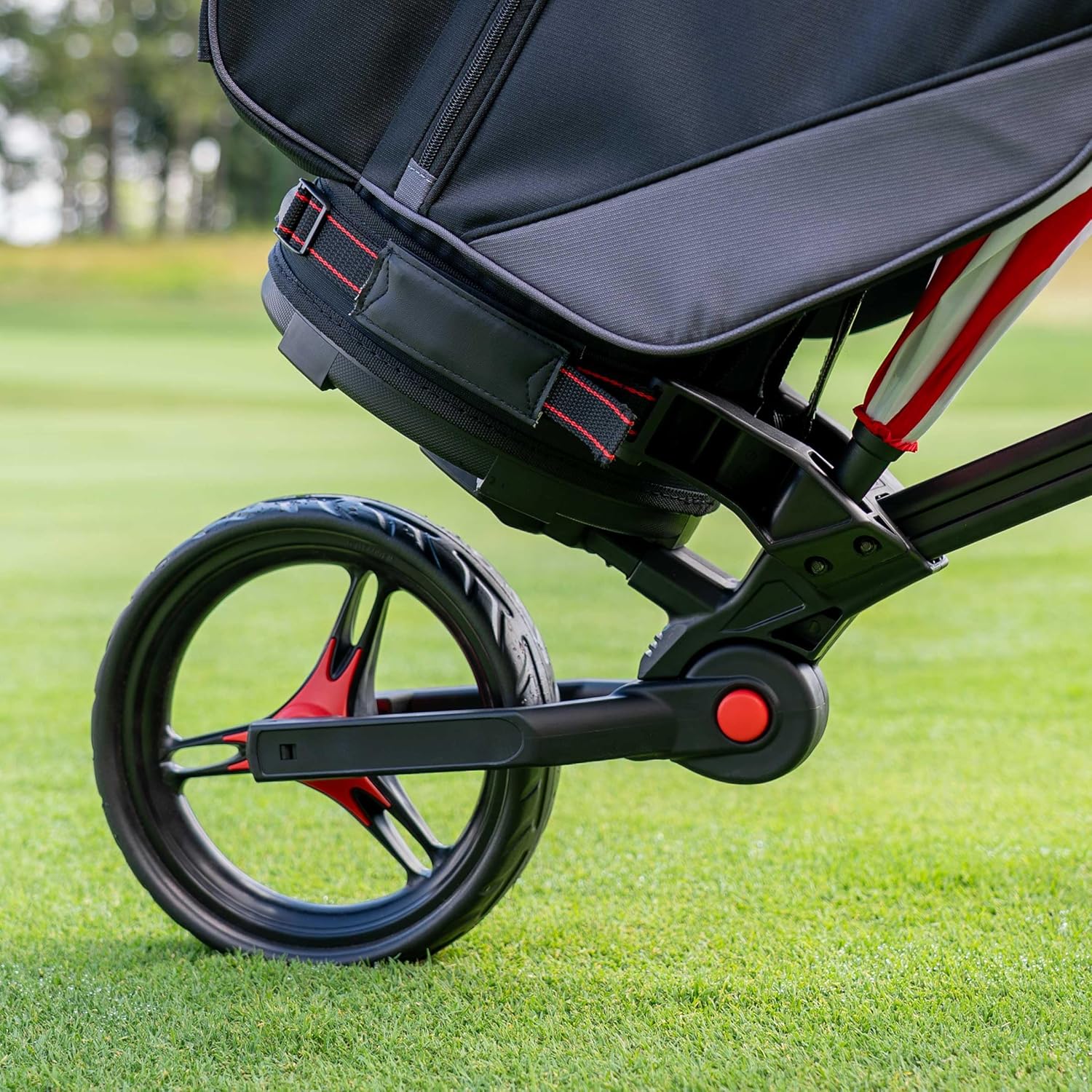 Close-up of the Bag Boy Compact 3 Golf Trolley's lower bag support and wheel on a golf course.