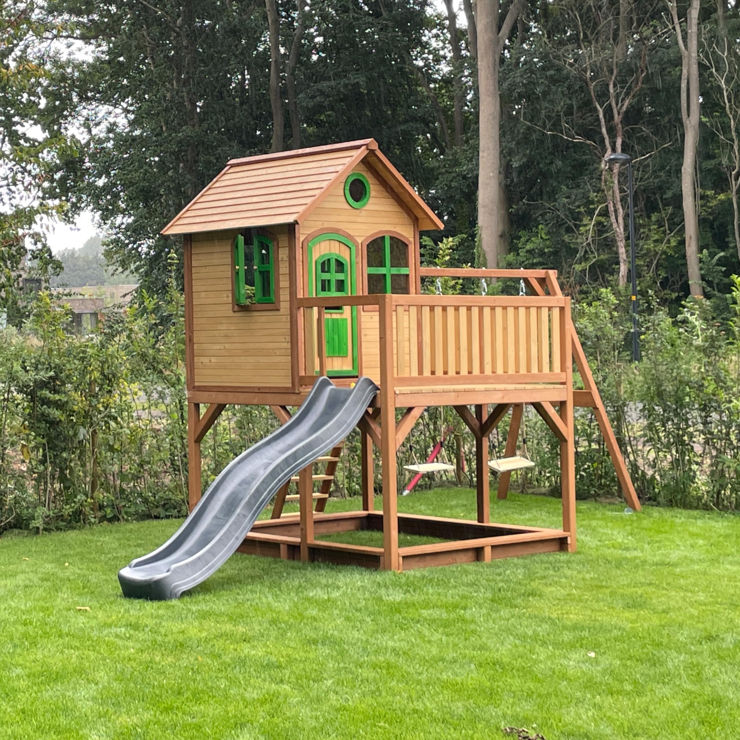 AXI Spielhaus Liam mit Sandkasten, Doppelschaukel & Grauer Rutsche | Stelzenhaus XXL in Braun & Grün aus FSC Holz für Kinder | Spielturm mit Wellenrutsche für den Garten
