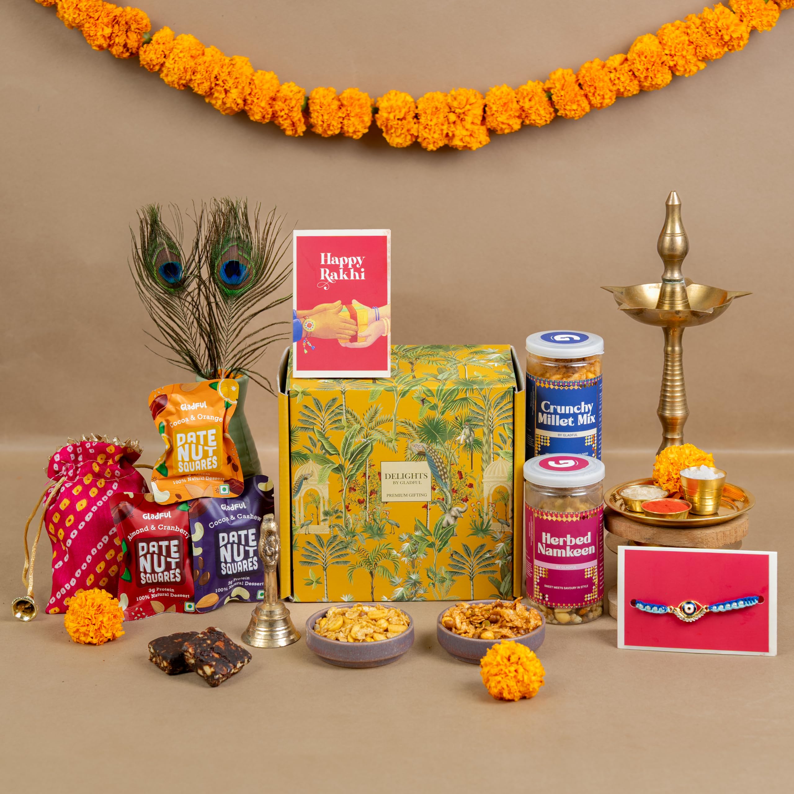 Gladful 9-in-1 Rakhi Celebration Box – Millet Mix, Namkeen, Date Nut Squares, Handmade Rakhi, Greeting Card, Roli Chawal & Potli