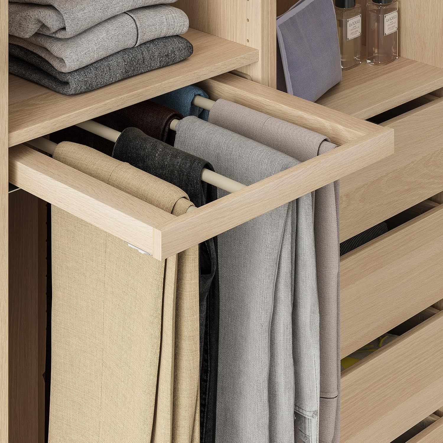 Ikea KOMPLEMENT Pull-Out Trouser Hanger installed in a wardrobe, extended with several pairs of trousers neatly hung on its bars.
