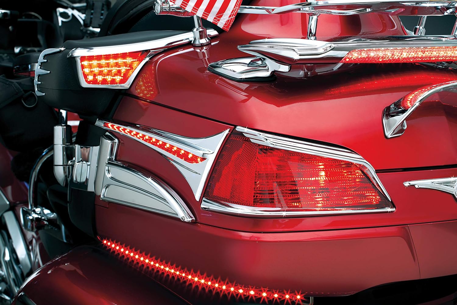 వెనుక view of a red Honda Gold Wing GL1800 with Kuryakyn 3240 LED Passenger Armrest Trim and other Kuryakyn lighting accessories, highlighting the integrated LED turn signals and running lights.