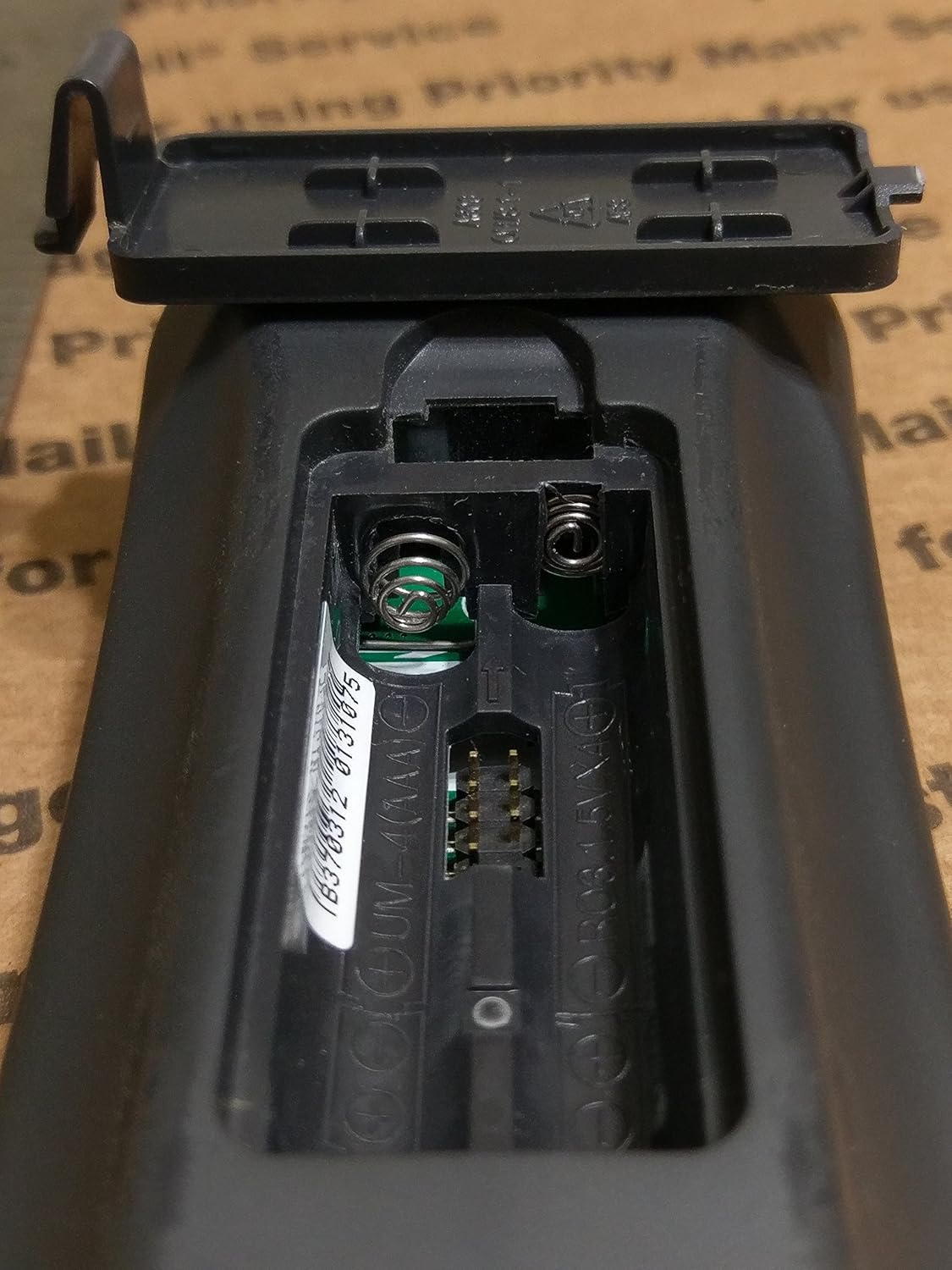 Open battery compartment of the Universal Remote Control MX-350 Osiris, showing the slots for four AAA batteries and the spring contacts.