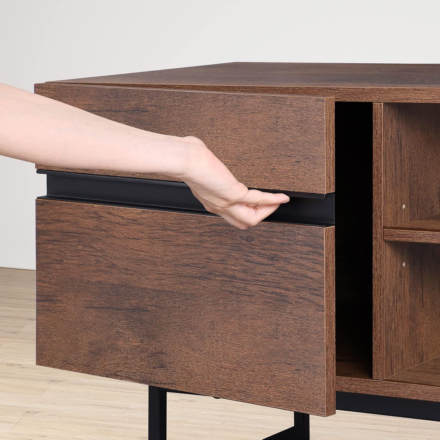 Hand opening a cabinet door on the TV stand
