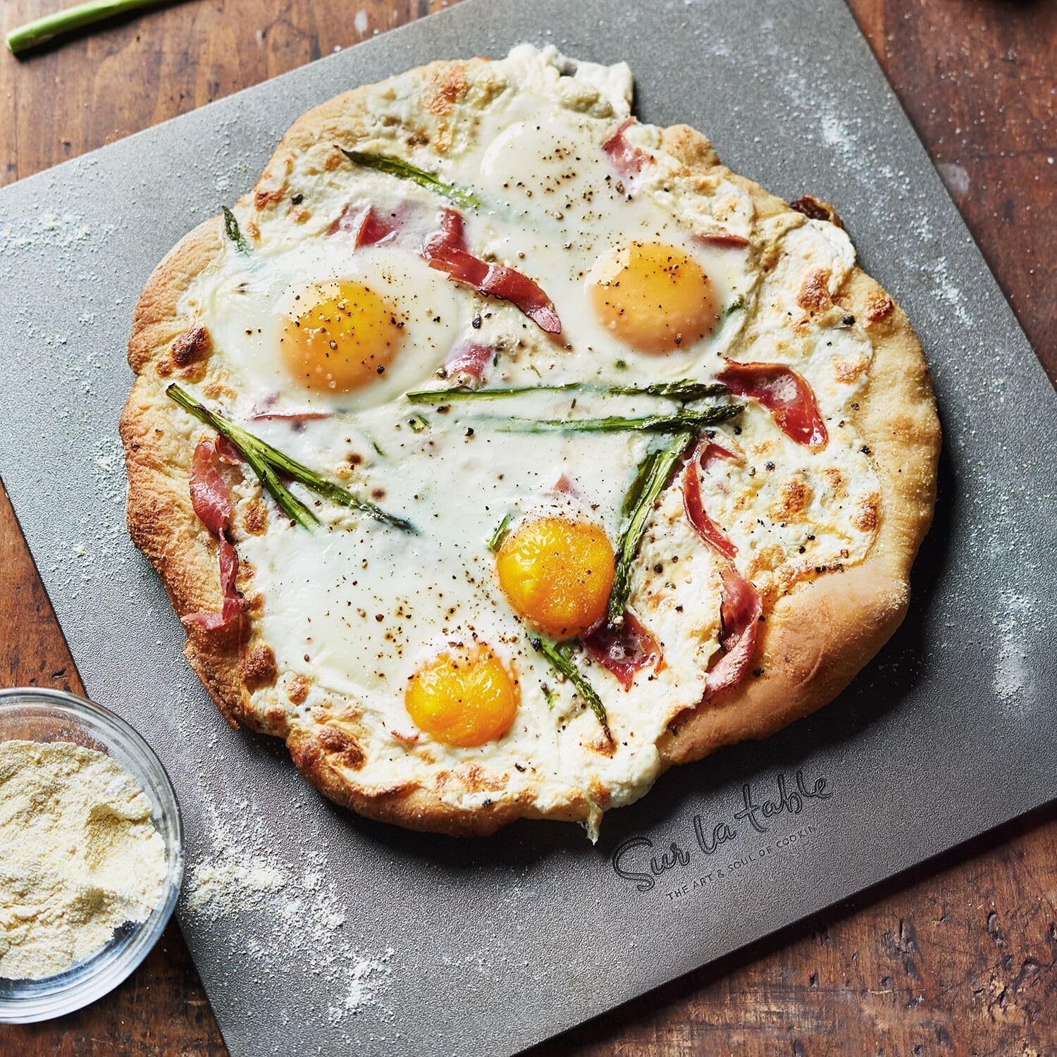 A breakfast pizza with eggs, bacon, and asparagus on the Sur La Table Baking Steel.