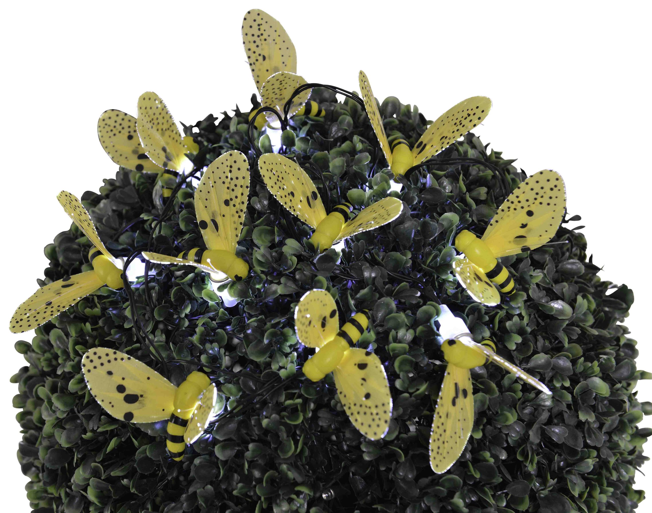 Close-up of bee-shaped LED lights on a green bush