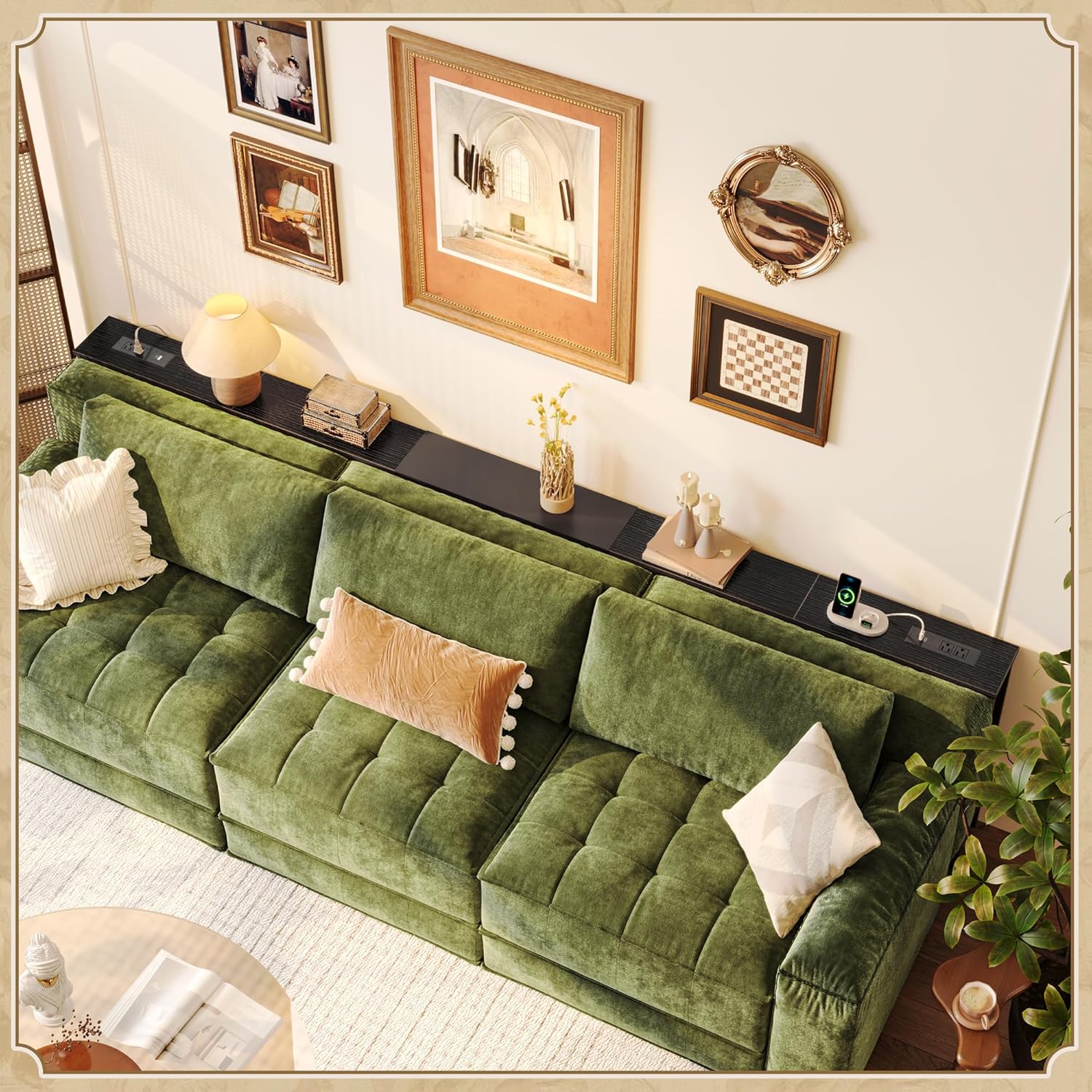 Sofa table behind a green sofa, adorned with various decorative items and a charging phone.