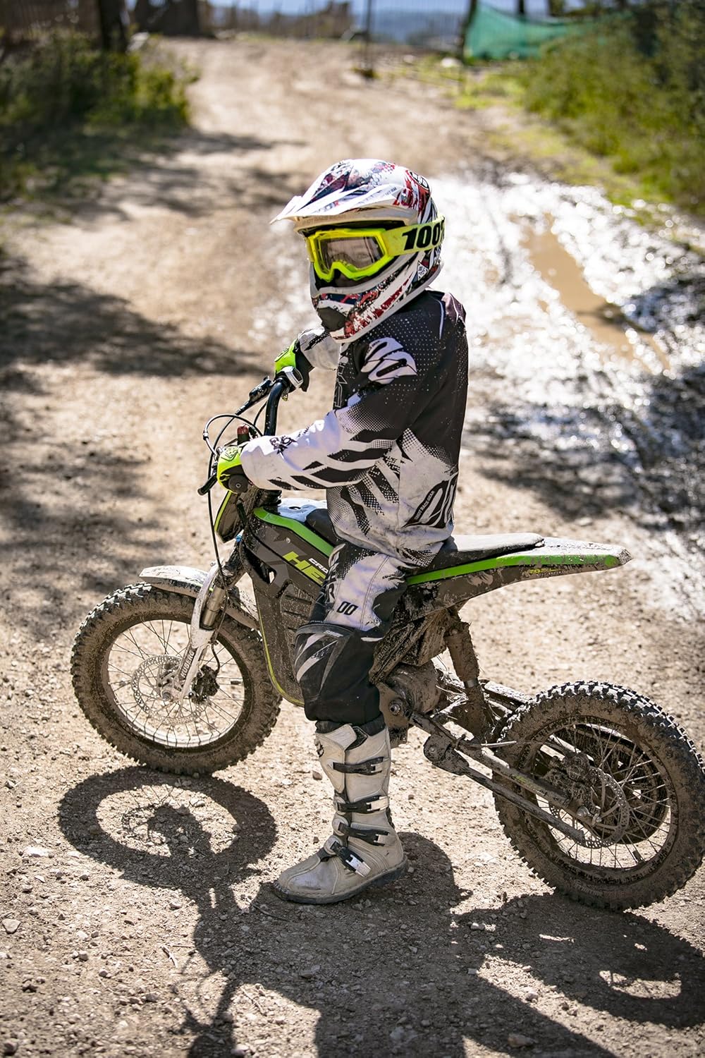 Young rider standing next to KUBERG Cross Hero on a dirt path