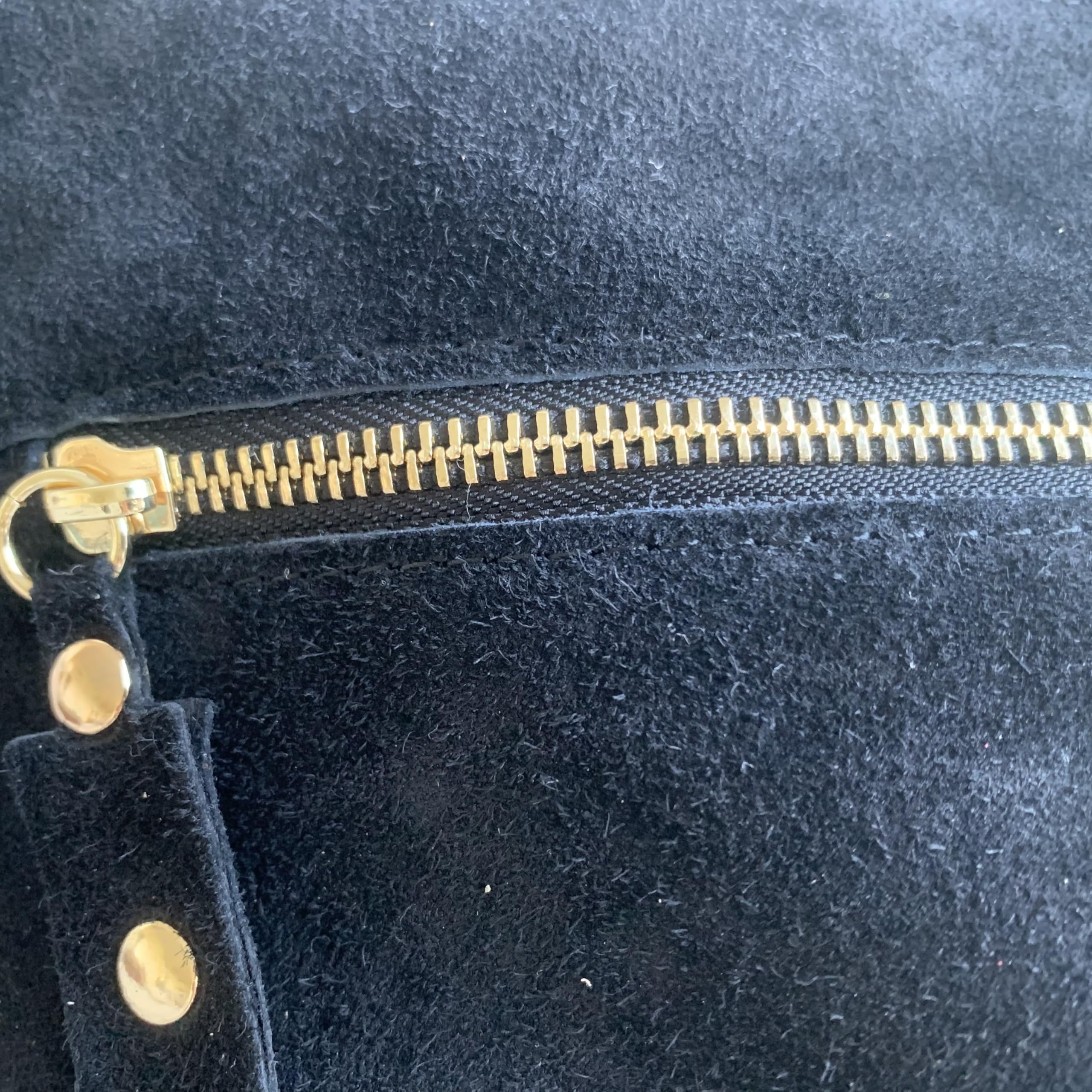 Borsa a tracolla in camoscio italiano con borchie sui lati. Cinturino regolabile e intercambiabile. Chiusura con cerniera. Interno foderato con tasca integrata. Tasca posteriore.