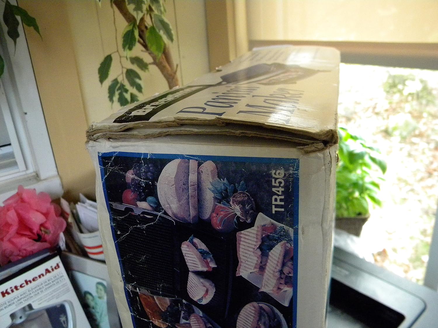 Breadman TR456 Panini Maker with a sandwich being grilled, showing the floating hinge in action.