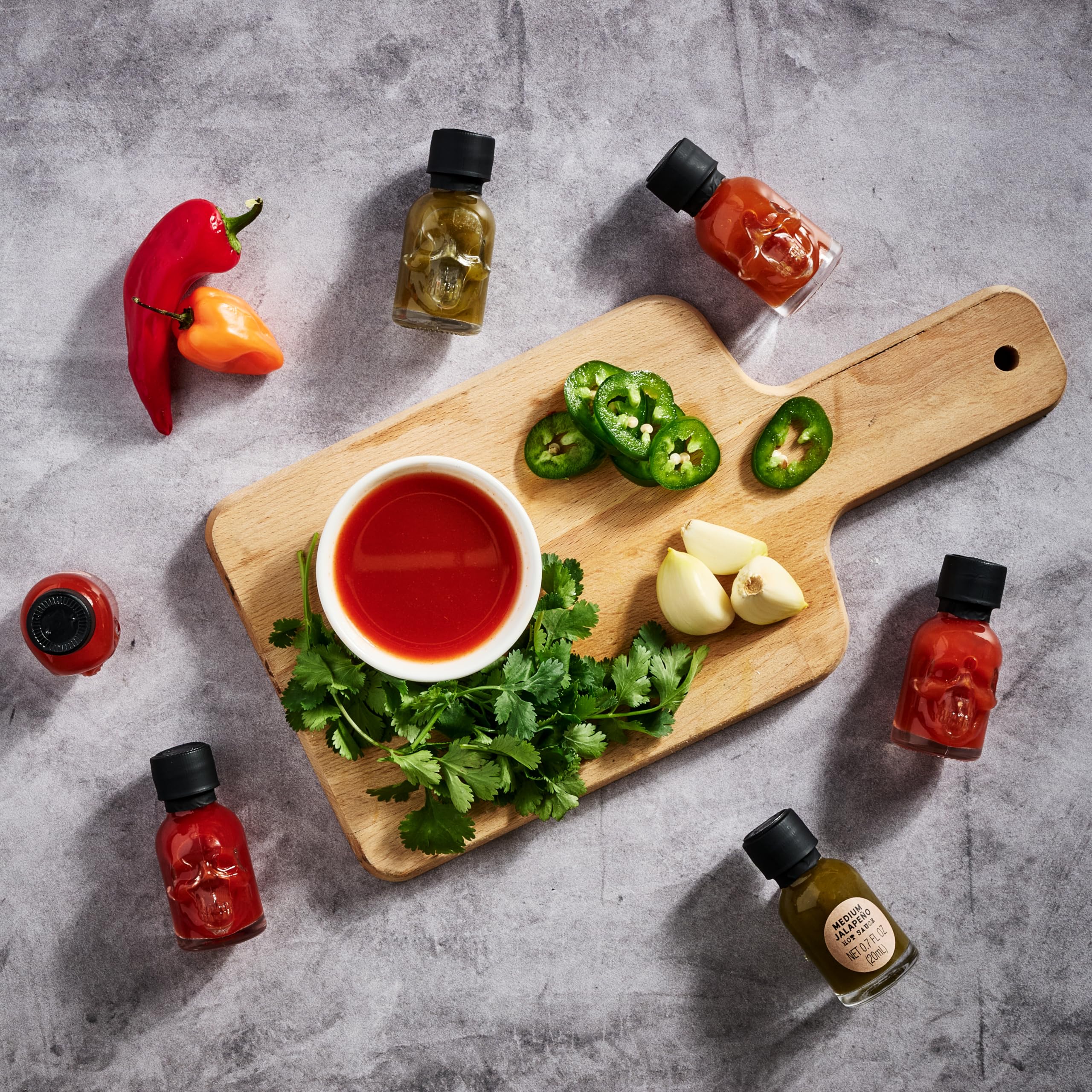 Man Crates: Surtido «Hot Sauce Inferno» — Incluye 21 sabores en mini botellas de salsa picante con forma de calavera; un desafío picante con habanero, chile fantasma y más.