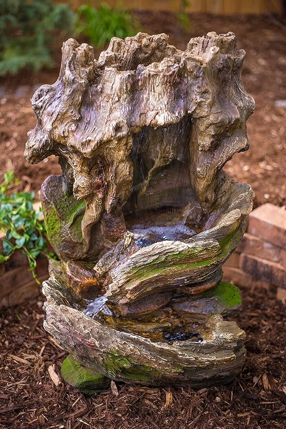 The 32" Cottage Log Garden Fountain is a tiered outdoor water feature designed for gardens and patios. Made of weatherproof resin, this fountain is durable and built to withstand outdoor conditions. The hand-crafted design adds a touch of charm to any outdoor space, while the LED lights provide a soothing ambiance for nighttime relaxation.