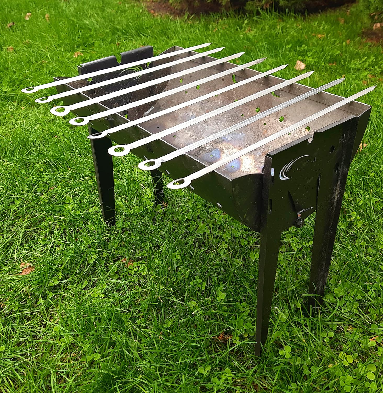 SYTON Mangal Grill with multiple skewers loaded with meat and vegetables cooking over charcoal.