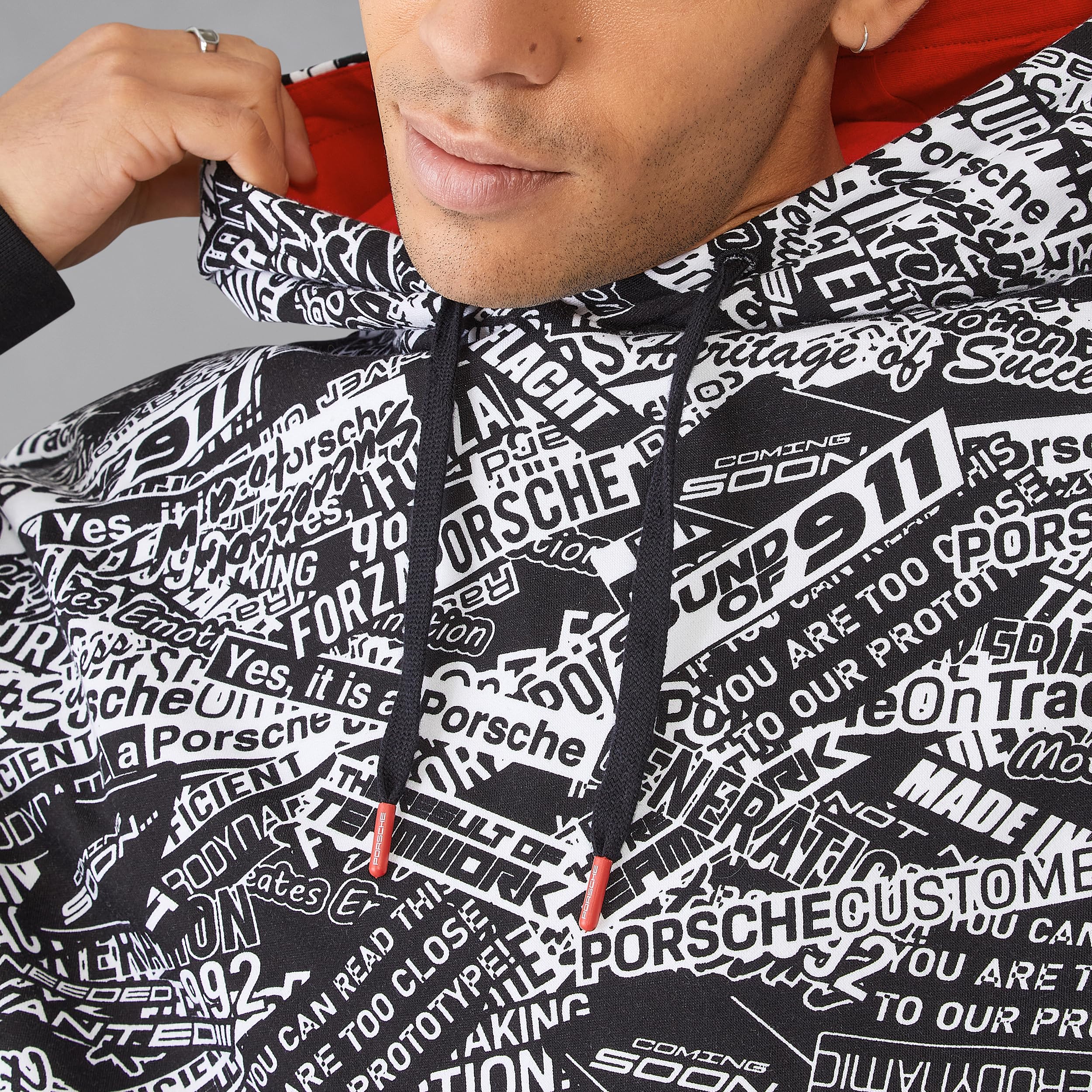 Porsche Motorsport Felpa con Cappuccio Oversize Stampata con Citazioni | Pile spazzolato, Stampa all-over con citazioni Porsche, Cappuccio regolabile con fodera rosso a contrasto