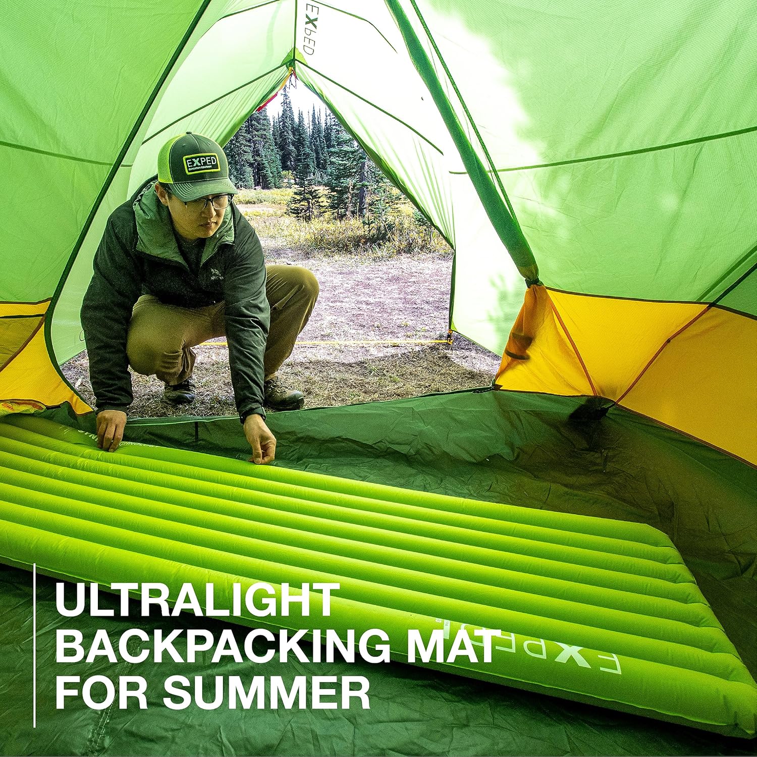 Man setting up Exped sleeping mat inside a tent