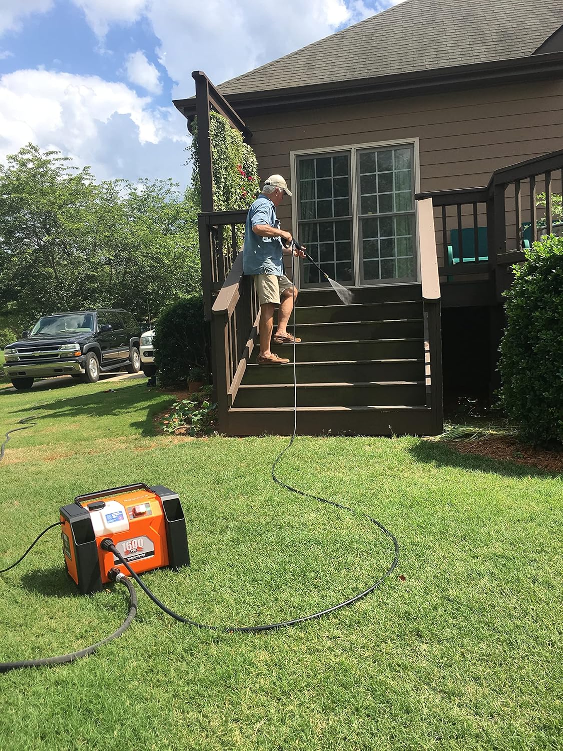 Person using pressure washer on outdoor stairs
