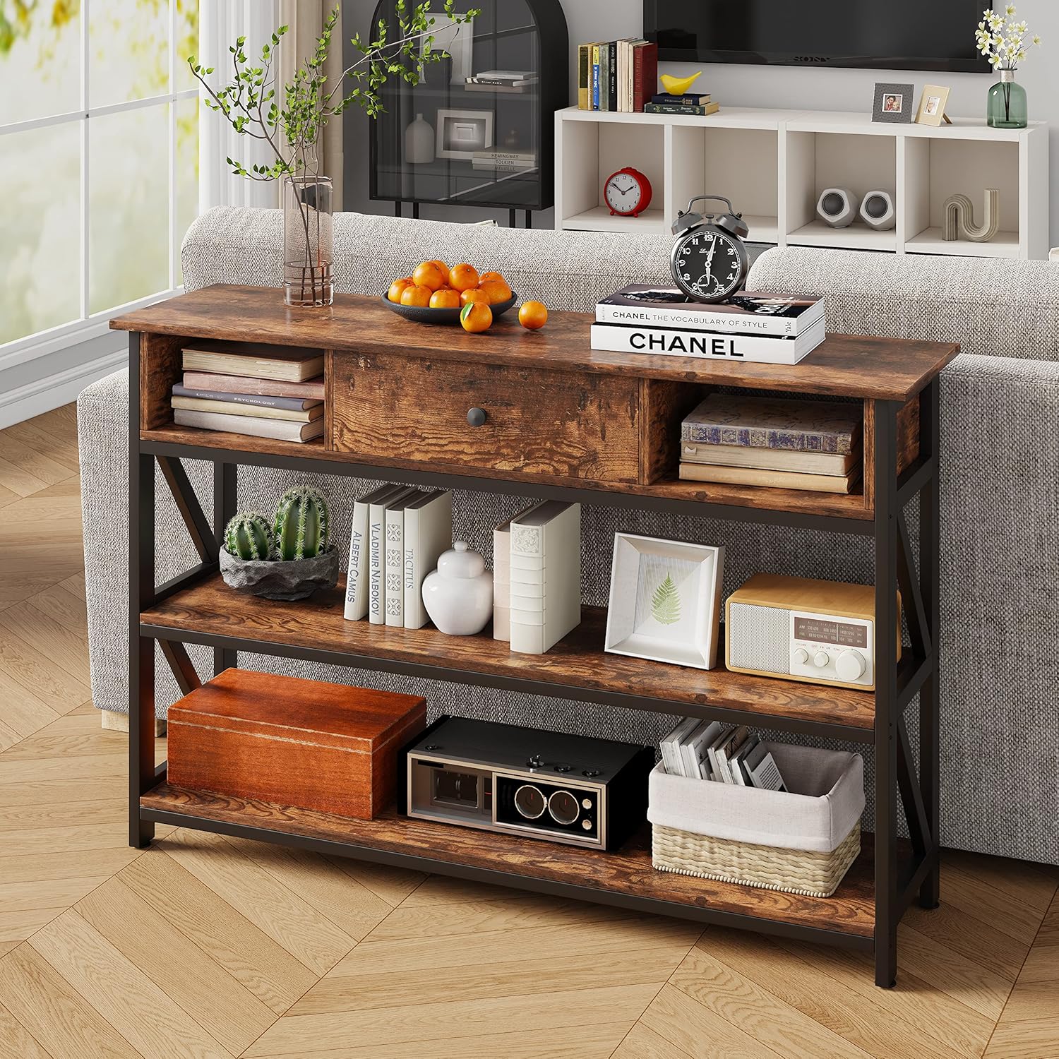 Mexin Console Table placed behind a sofa in a living room, adorned with books, plants, and decorative objects.