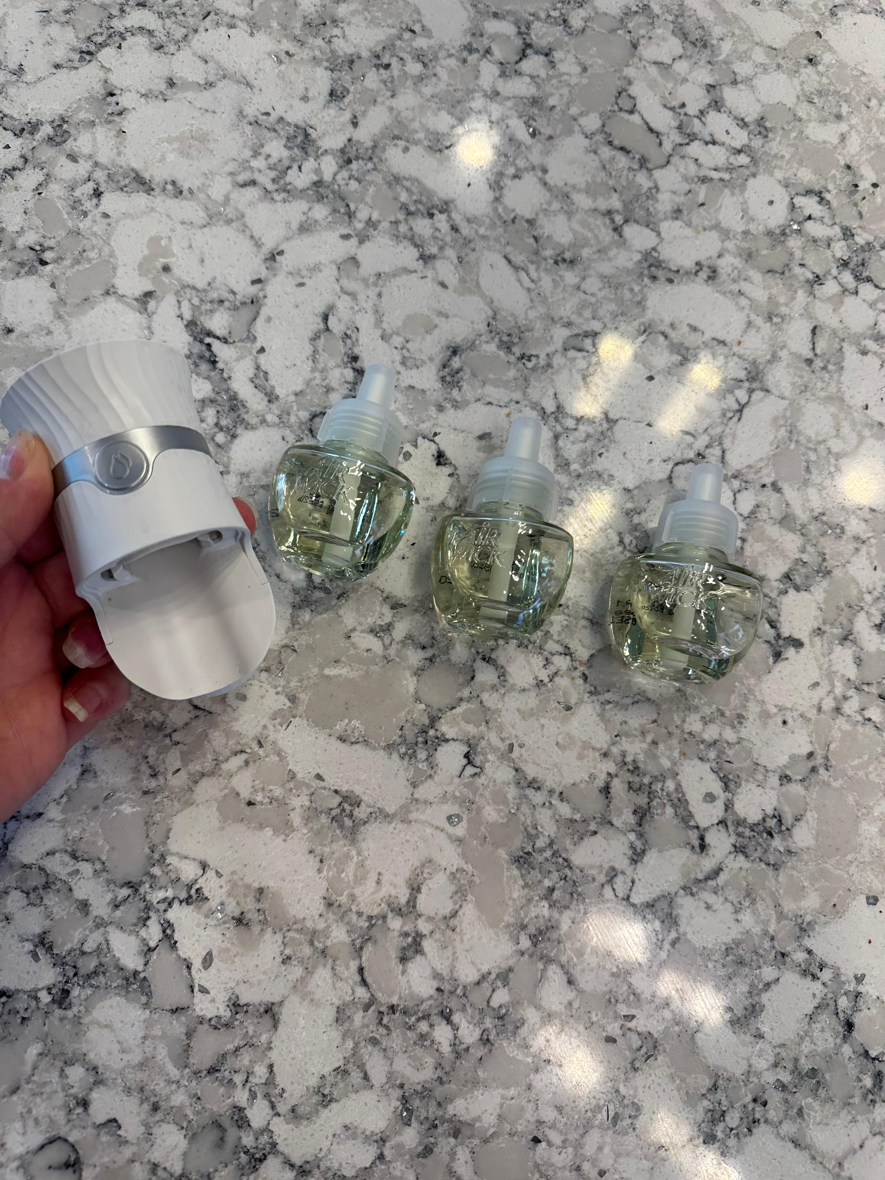 Air Wick Advanced Plug-In Warmer plugged into an outlet, showing the top dial for fragrance settings