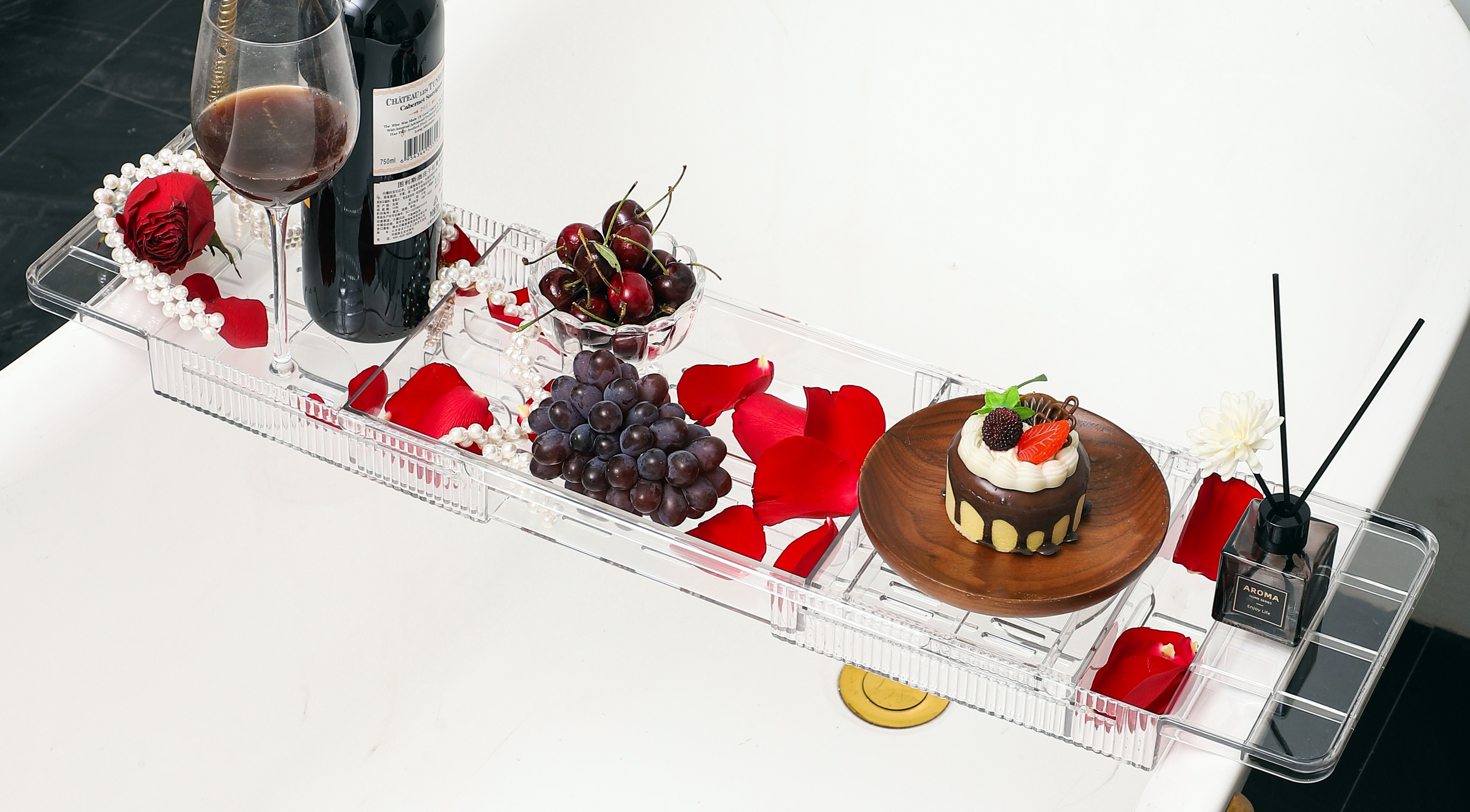 Wooden Tray With Tablet, Wine, Candles And Toiletries On Bathtub In Bathroom Stock Photo