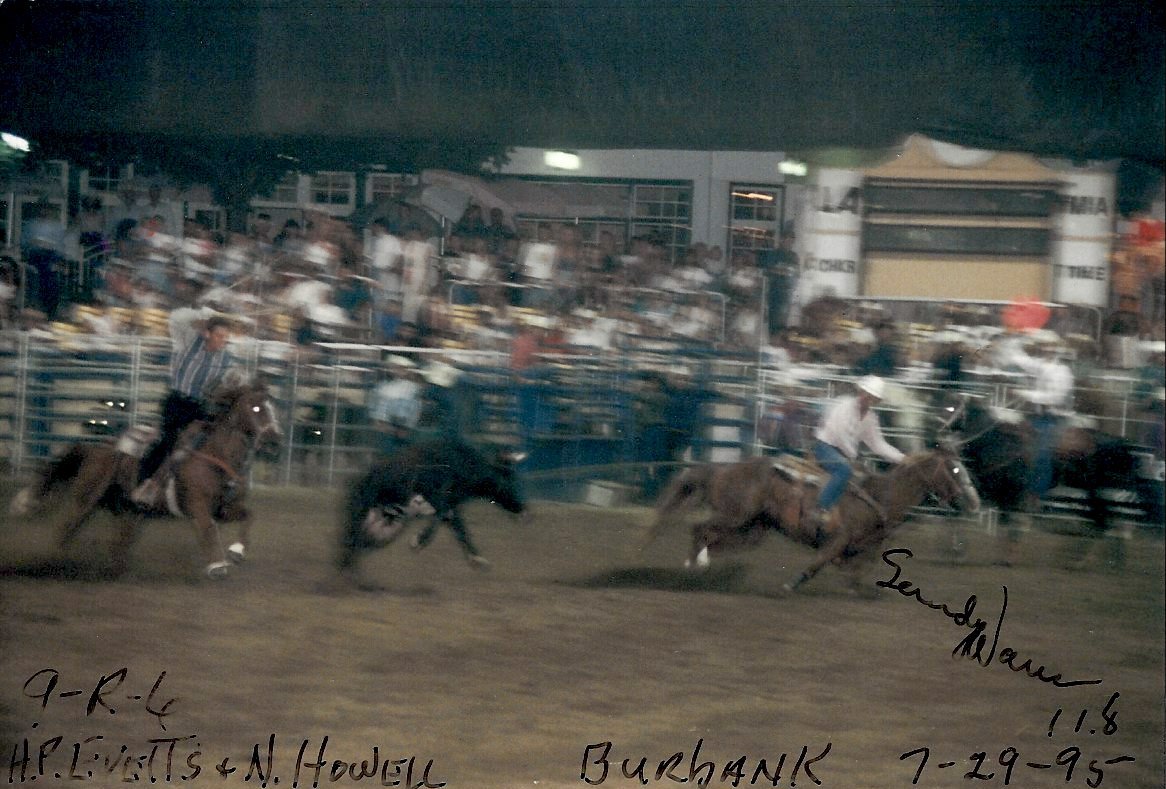 Norman Howell riding in a rodeo with world champion H.P. Evetts