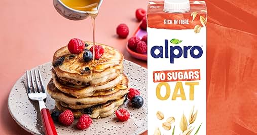 Alpro oat drink advertisement featuring stack of pancakes with berries and text 'YOU SAY NO TO SUGARS. WE GOT YOU.' with product package.