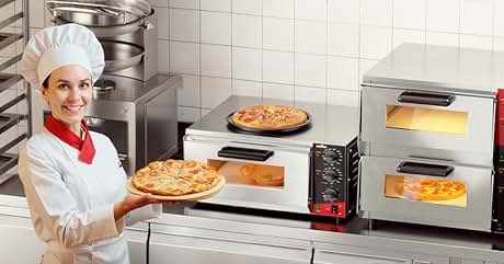 de cocina comercial con hornos para pizza, bandejas calientes y productos horneados. Chef con uniforme blanco y sombrero sosteniendo una pizza recién horneada. Bandejas apiladas de panecillos visibles a la izquierda