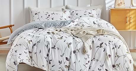 una cama con una funda nórdica con estampado floral y una manta.