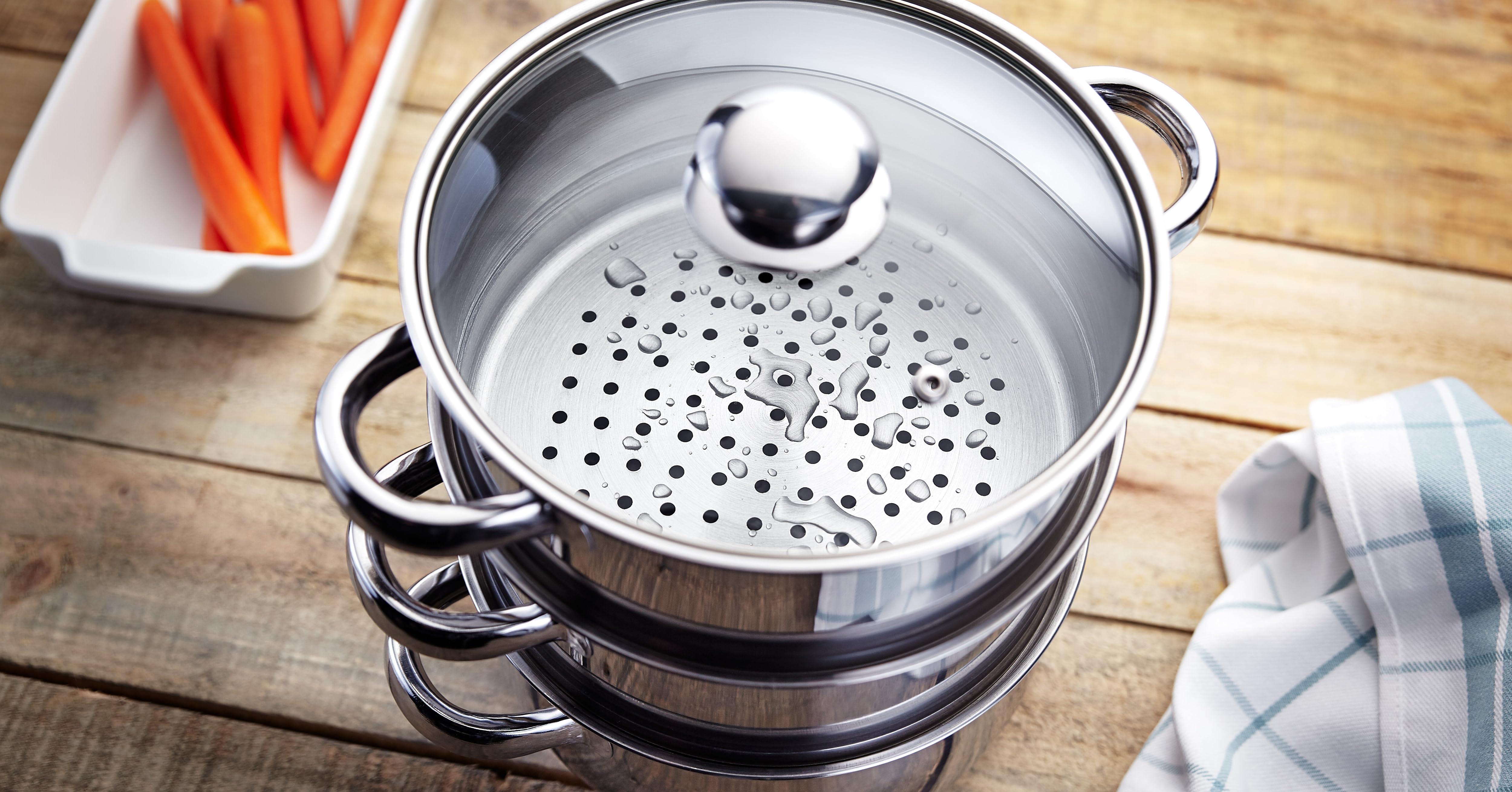 Close-up of a stainless steel colander or steamer basket with numerous small holes, sitting inside a metal pot or pan.