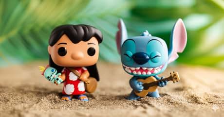 El texto dice «Imagen 1". Dos figuras de dibujos animados sobre arena. Izquierda: personaje vestido de rojo con ukelele. Derecha: criatura azul parecida a un alienígena tocando la guitarra. Fondo de follaje verde borroso