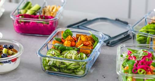 Glass food storage containers with colorful salads and ingredients. Showcases meal prep and fresh food storage solutions for organized, healthy eating.