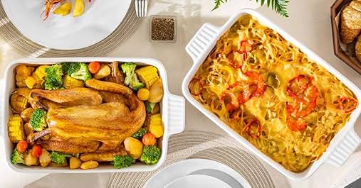 Overhead view of two baking dishes: one with a whole roasted chicken and vegetables, another with a cheesy pasta dish topped with red peppers. A small dish of seasoning is visible.