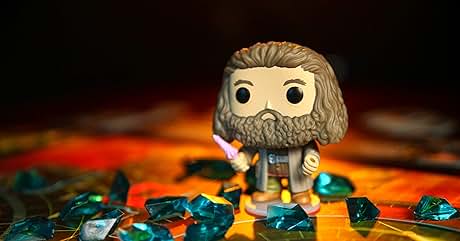 de estilo caricaturizado con cabeza y barba grandes rodeadas de pequeñas piedras preciosas de color verde azulado sobre una superficie naranja con una iluminación