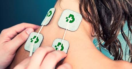 Primer plano del hombro de una persona con cuatro almohadillas adhesivas cuadradas, cada una con un símbolo de reciclaje verde