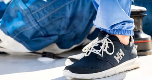 un primer plano de una enfermera con bata y zapatillas azules